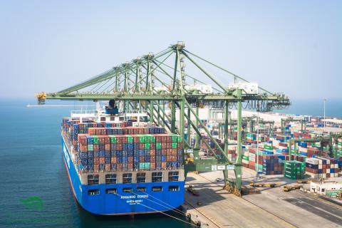 Container ship coming into a port with cranes overhead